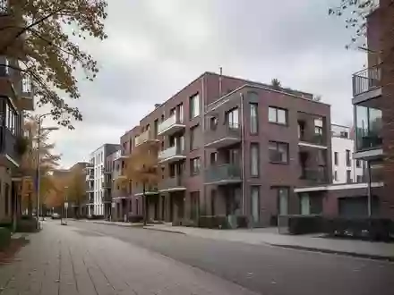Eine ruhige Wohnstraße mit modernen Mehrfamilienhäusern an einem bewölkten Herbsttag. - Foto: über boerse-global.de