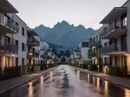 Moderne Wohngebäude in Bregenz vor einer alpinen Kulisse in der Dämmerung. - Foto: über boerse-global.de