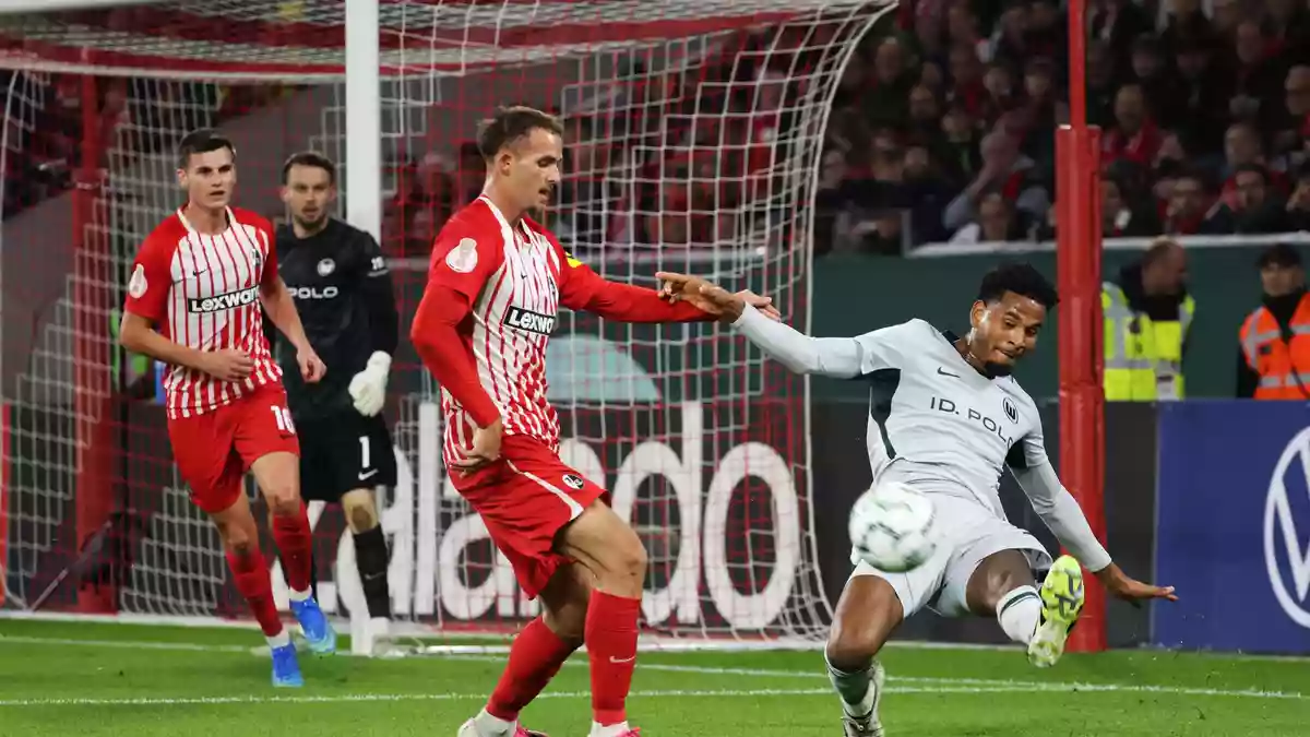 Heißer Pokaltanz in Freiburg: Wolfsburgs Cleiton (r) grätscht den Ball vor SC-Spieler Max Rosenfelder weg. - Bild: Philipp von Ditfurth/dpa