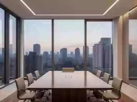 Ein minimalistisch gestalteter, leerer Konferenzraum mit großen Fensterfronten in einem modernen Bürogebäude bei Dämmerung. - Foto: über boerse-global.de