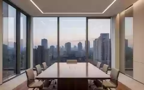 Ein minimalistisch gestalteter, leerer Konferenzraum mit großen Fensterfronten in einem modernen Bürogebäude bei Dämmerung. - Foto: über boerse-global.de