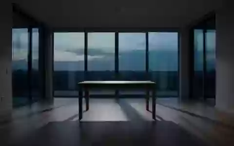 Ein minimalistisches, leeres Wohnzimmer in der Abenddämmerung, das eine Atmosphäre von Stille und emotionaler Distanz vermittelt. - Foto: über boerse-global.de
