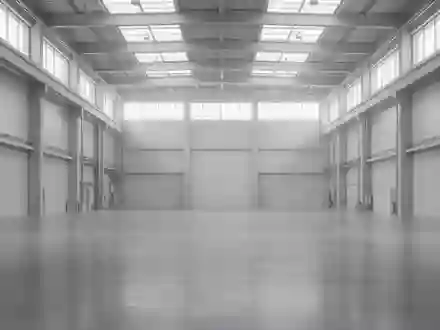 Eine weitläufige, leere Industriehalle mit poliertem Betonboden und minimalistischer Architektur bei diffusem Tageslicht. - Foto: über boerse-global.de