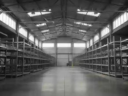 Leere, industriell genutzte Lagerhalle mit hohen Regalen und Betonboden in einer sachlichen Architekturaufnahme. - Foto: über boerse-global.de