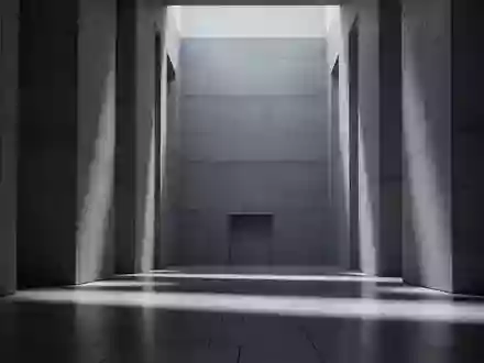 Ein minimalistischer, moderner Innenraum eines Regierungsgebäudes mit Betonwänden und langgezogenen Schatten auf einem Steinfußboden. - Foto: über boerse-global.de