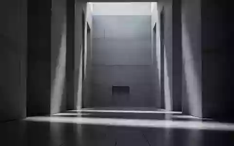 Ein minimalistischer, moderner Innenraum eines Regierungsgebäudes mit Betonwänden und langgezogenen Schatten auf einem Steinfußboden. - Foto: über boerse-global.de