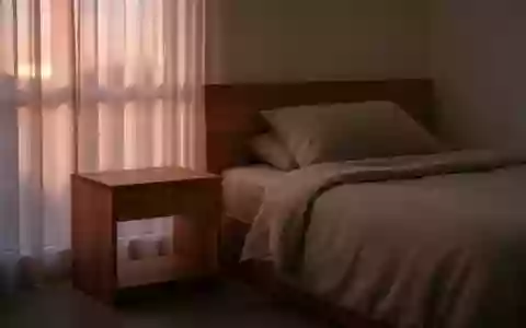Ein minimalistisches, ruhiges Schlafzimmer bei Dämmerung ohne elektronische Geräte, das Erholung und digitale Abstinenz symbolisiert. - Foto: über boerse-global.de