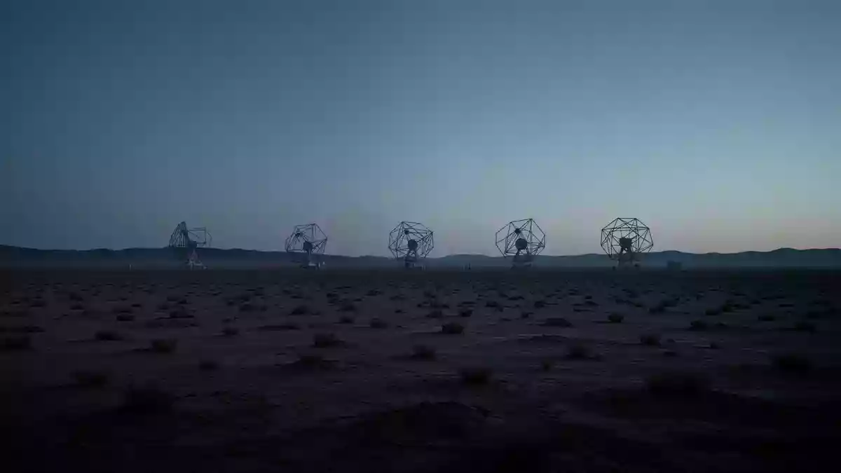 Eine weitläufige Wüstenlandschaft bei Dämmerung mit silhouettierten Satellitenantennen am Horizont. Illustration mit AI erstellt.