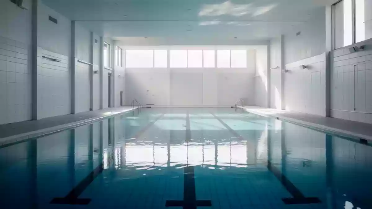 Ein leeres, modernes Hallenbad mit klarem blauem Wasser und hellen Fliesen in einer ruhigen Atmosphäre. Illustration mit AI erstellt.