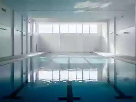 Ein leeres, modernes Hallenbad mit klarem blauem Wasser und hellen Fliesen in einer ruhigen Atmosphäre. - Foto: über boerse-global.de