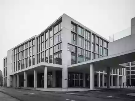 Modernes Bürogebäude in minimalistischer Architektur bei bewölktem Himmel als Symbol für berufliche Stabilität. - Foto: über boerse-global.de