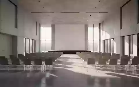 Ein heller, moderner Konferenzsaal mit leerer Bestuhlung und großen Fensterfronten in einem architektonisch minimalistischen Stil. - Foto: über boerse-global.de