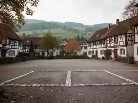 Ein leerer, ländlicher Parkplatz auf einem Dorfplatz in Baden-Württemberg mit zwei markierten Stellplätzen. - Foto: über boerse-global.de