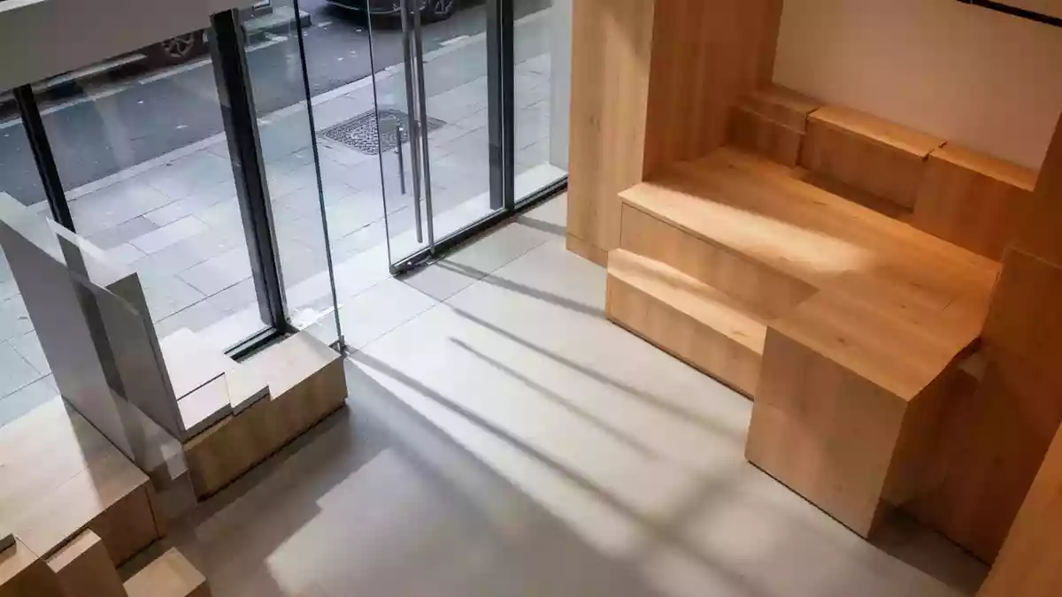 Ein heller, minimalistisch gestalteter Verkaufsraum mit natürlichem Lichteinfall und klaren architektonischen Linien. Illustration mit AI erstellt.