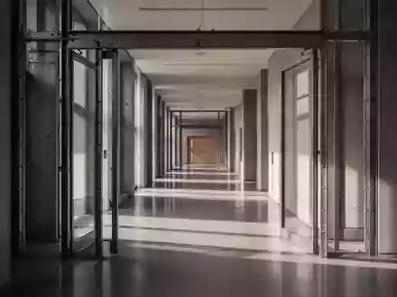 Leerer Flur in einem modernen Universitätsgebäude mit Stahltüren und klaren architektonischen Linien. - Foto: über boerse-global.de