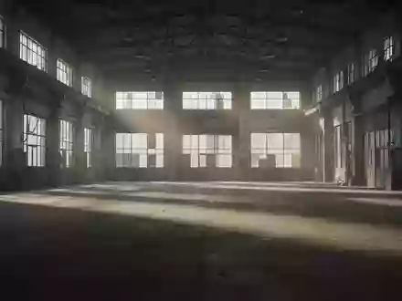 Eine leere, weitläufige Industriehalle mit Betonboden und hohen Fenstern, die lange Schatten wirft. - Foto: über boerse-global.de