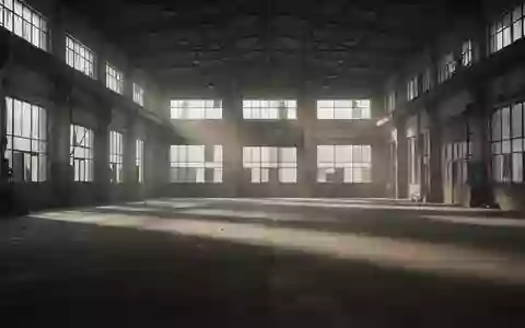 Eine leere, weitläufige Industriehalle mit Betonboden und hohen Fenstern, die lange Schatten wirft. - Foto: über boerse-global.de