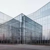 Moderne Industriefassade eines Firmengebäudes mit klaren architektonischen Linien und Glasfront bei bedecktem Himmel. - Foto: über boerse-global.de