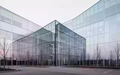 Moderne Industriefassade eines Firmengebäudes mit klaren architektonischen Linien und Glasfront bei bedecktem Himmel. - Foto: über boerse-global.de