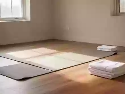 Ein minimalistischer, lichtdurchfluteter Raum für Physiotherapie mit einer ausgebreiteten Yogamatte auf einem Holzboden. - Foto: über boerse-global.de