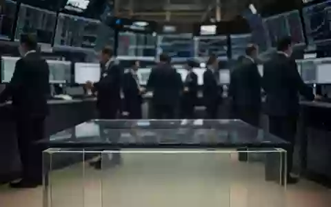 Ein moderner, menschenleerer Handelsraum in gedimmtem Licht mit Fokus auf einen leeren Schreibtisch. - Foto: über boerse-global.de
