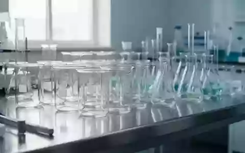 Leere Laborgefäße aus Glas auf einer Edelstahloberfläche in einer sterilen Umgebung. - Foto: über boerse-global.de
