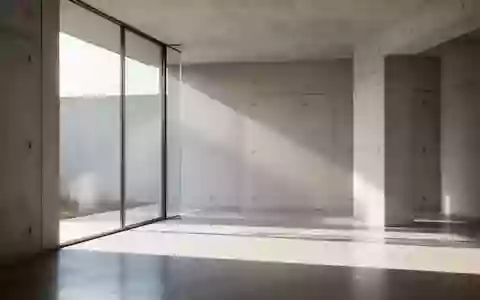 Ein minimalistischer, heller Architekturraum mit klaren geometrischen Schatten und einfallendem Tageslicht. - Foto: über boerse-global.de
