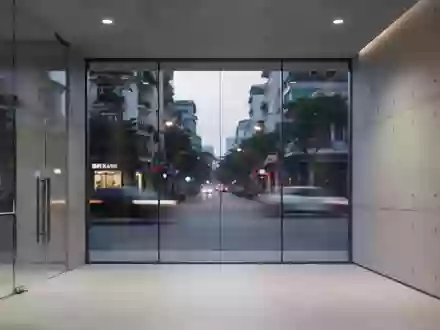 Ein minimalistisch gestalteter Innenraum einer modernen Bank mit Betonwänden und großen Glasfronten bei Dämmerung. - Foto: über boerse-global.de