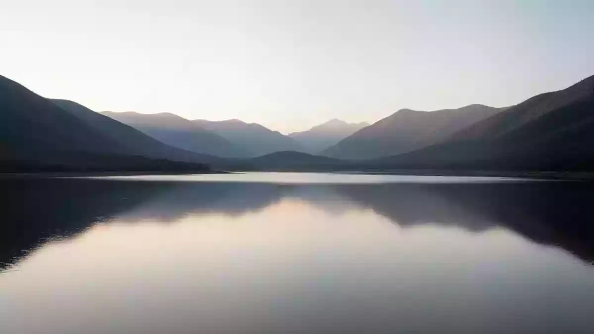 Eine ruhige Seenlandschaft bei Dämmerung, die Ausgeglichenheit und innere Ruhe symbolisiert. Illustration mit AI erstellt.