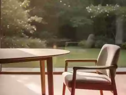 Ein lichtdurchfluteter, ruhiger Raum mit einem Holztisch und Blick in einen grünen Garten, der eine Atmosphäre der Geborgenheit vermittelt. - Foto: über boerse-global.de