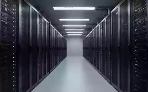Ein minimalistischer, moderner Serverraum mit ordentlich angeordneten, dunklen Server-Racks in einem symmetrischen Flur. - Foto: über boerse-global.de