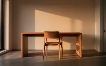 Ein ruhiger, minimalistischer Homeoffice-Arbeitsplatz mit einem leeren Stuhl und sanftem Tageslicht. - Foto: über boerse-global.de