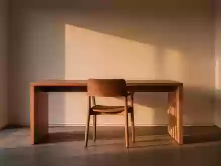 Ein ruhiger, minimalistischer Homeoffice-Arbeitsplatz mit einem leeren Stuhl und sanftem Tageslicht. - Foto: über boerse-global.de