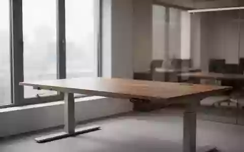 Ein leerer, ergonomischer Arbeitsplatz mit einem höhenverstellbaren Schreibtisch in einem hellen, ruhigen Büro. - Foto: über boerse-global.de