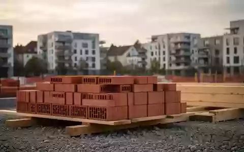 Baustelle mit ordentlich gestapelten Ziegeln und Holzbalken vor einer Kulisse moderner Wohngebäude in einer Stadt. - Foto: über boerse-global.de