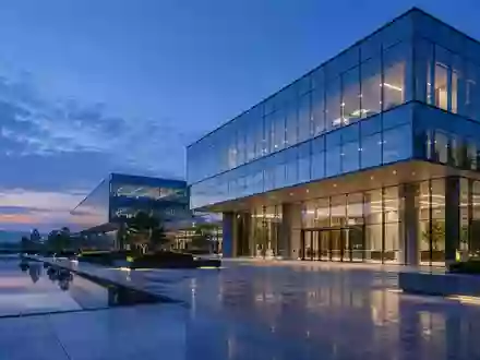 Ein modernes, minimalistisches Bürogebäude in der Abenddämmerung mit klaren architektonischen Linien und Glasfassade. - Foto: über boerse-global.de