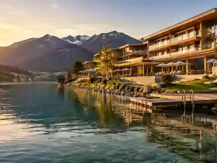 Ein modernes Luxushotel in der malerischen Landschaft des Tegernsees bei Sonnenuntergang. - Foto: über boerse-global.de
