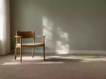 Ein minimalistischer, ruhiger Therapieraum mit natürlichem Licht, einem einzelnen Holzstuhl und dezenten Farben. - Foto: über boerse-global.de