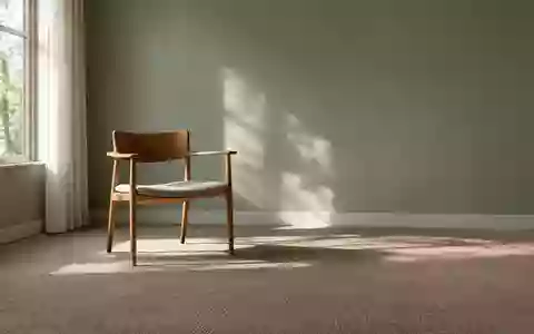 Ein minimalistischer, ruhiger Therapieraum mit natürlichem Licht, einem einzelnen Holzstuhl und dezenten Farben. - Foto: über boerse-global.de
