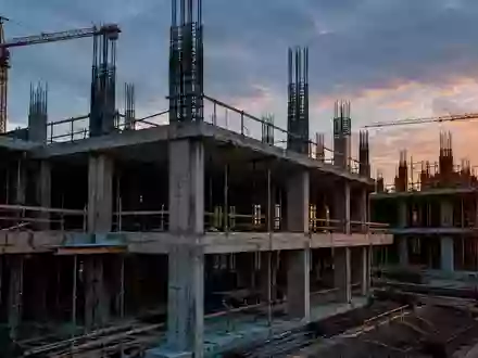 Rohbau einer modernen Baustelle mit freiliegenden Betonstrukturen und Stahlbewehrungen in der Dämmerung. - Foto: über boerse-global.de