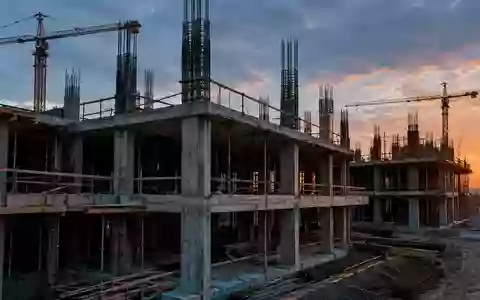 Rohbau einer modernen Baustelle mit freiliegenden Betonstrukturen und Stahlbewehrungen in der Dämmerung. - Foto: über boerse-global.de