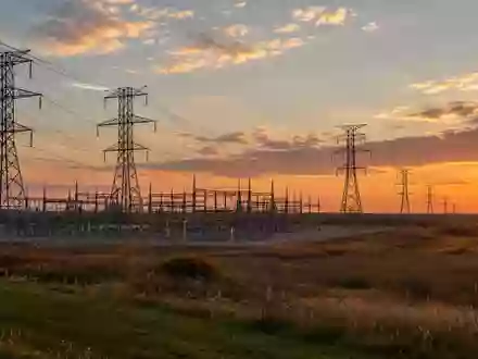 Eine weitläufige Landschaft mit Hochspannungsmasten und Stromleitungen bei Sonnenuntergang in Ohio. - Foto: über boerse-global.de