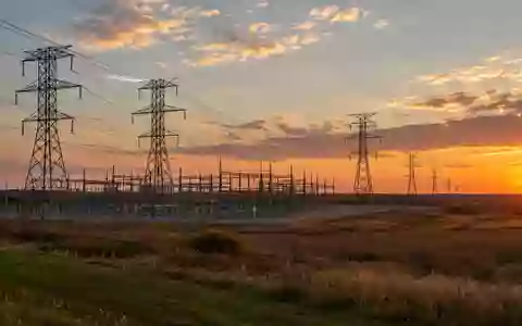 Eine weitläufige Landschaft mit Hochspannungsmasten und Stromleitungen bei Sonnenuntergang in Ohio. - Foto: über boerse-global.de