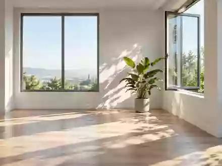 Ein minimalistisches, lichtdurchflutetes Büro mit einer Pflanze und einem geöffneten Fenster, das natürliches Licht einlässt. - Foto: über boerse-global.de
