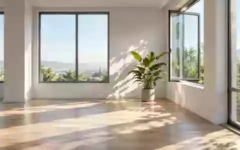 Ein minimalistisches, lichtdurchflutetes Büro mit einer Pflanze und einem geöffneten Fenster, das natürliches Licht einlässt. - Foto: über boerse-global.de