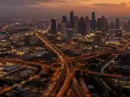 Ein weitläufiger Blick aus der Vogelperspektive auf das nächtliche Straßennetz von Houston, Texas, bei Dämmerung. - Foto: über boerse-global.de