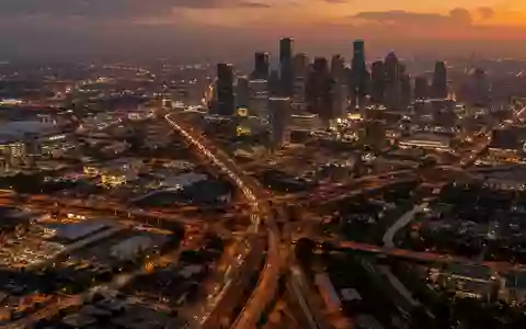 Ein weitläufiger Blick aus der Vogelperspektive auf das nächtliche Straßennetz von Houston, Texas, bei Dämmerung. - Foto: über boerse-global.de