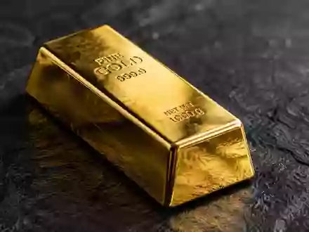 Ein glänzender Goldbarren auf einer dunklen Schieferplatte mit weicher, cinematischer Beleuchtung. - Foto: über boerse-global.de