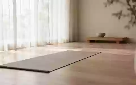 Ein minimalistischer, lichtdurchfluteter Raum für Entspannung und Meditation mit einer Yogamatte auf einem Holzboden. - Foto: über boerse-global.de