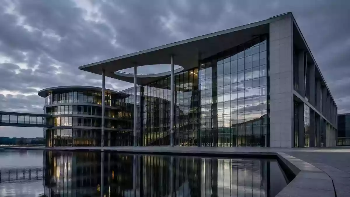 Moderne Glas- und Stahlfassade eines Behördengebäudes bei Dämmerung, Architekturaufnahme ohne Text. Illustration mit AI erstellt.